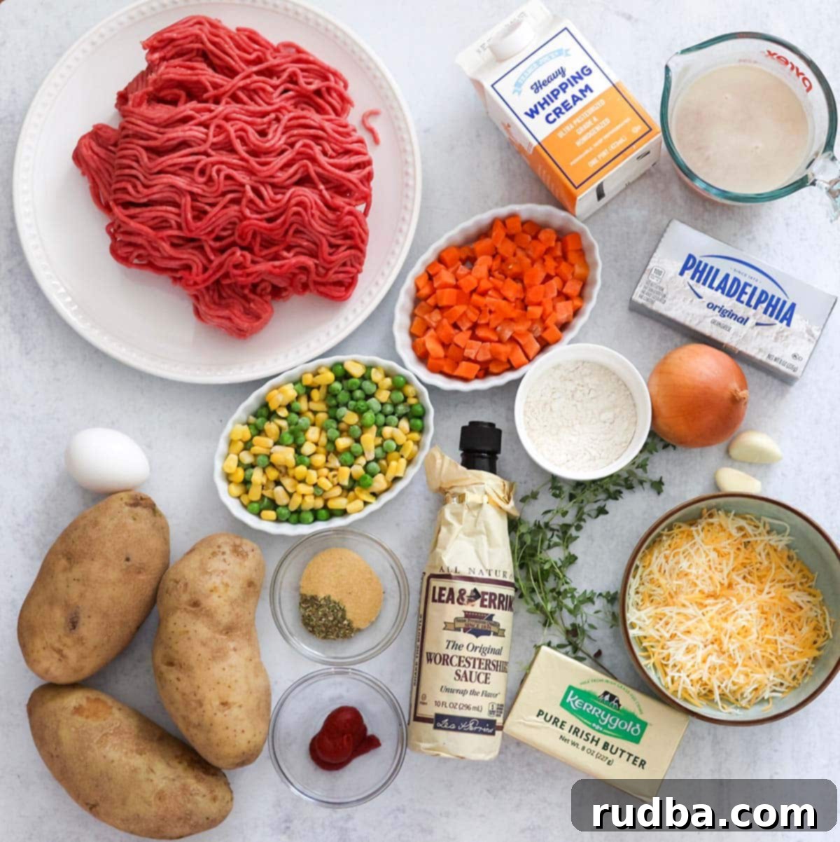 Golden Crust Beef and Mash 3 A flat lay of fresh ingredients laid out for making Cottage Pie, including ground beef, potatoes, carrots, peas, corn, and spices.
