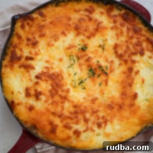 Golden Crust Beef and Mash 6 A close-up of a Cottage Pie in a red skillet, showcasing the golden mashed potato topping and rich filling.