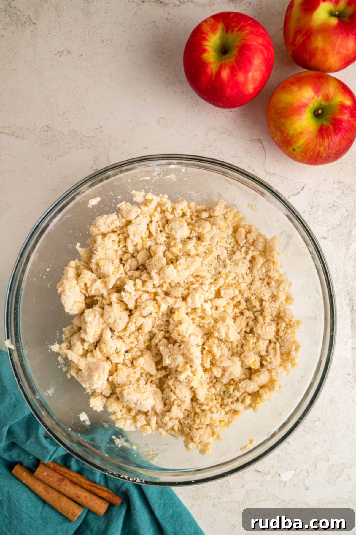 Warm Spiced Apple Pie 4 Hands mixing butter into flour for pie crust, showing the crumbly texture of a homemade pastry dough.