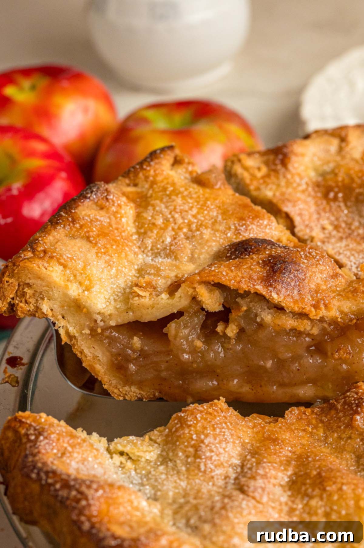 Warm Spiced Apple Pie 7 A perfectly baked slice of apple pie, revealing a thick, spiced apple filling and a golden, flaky crust.