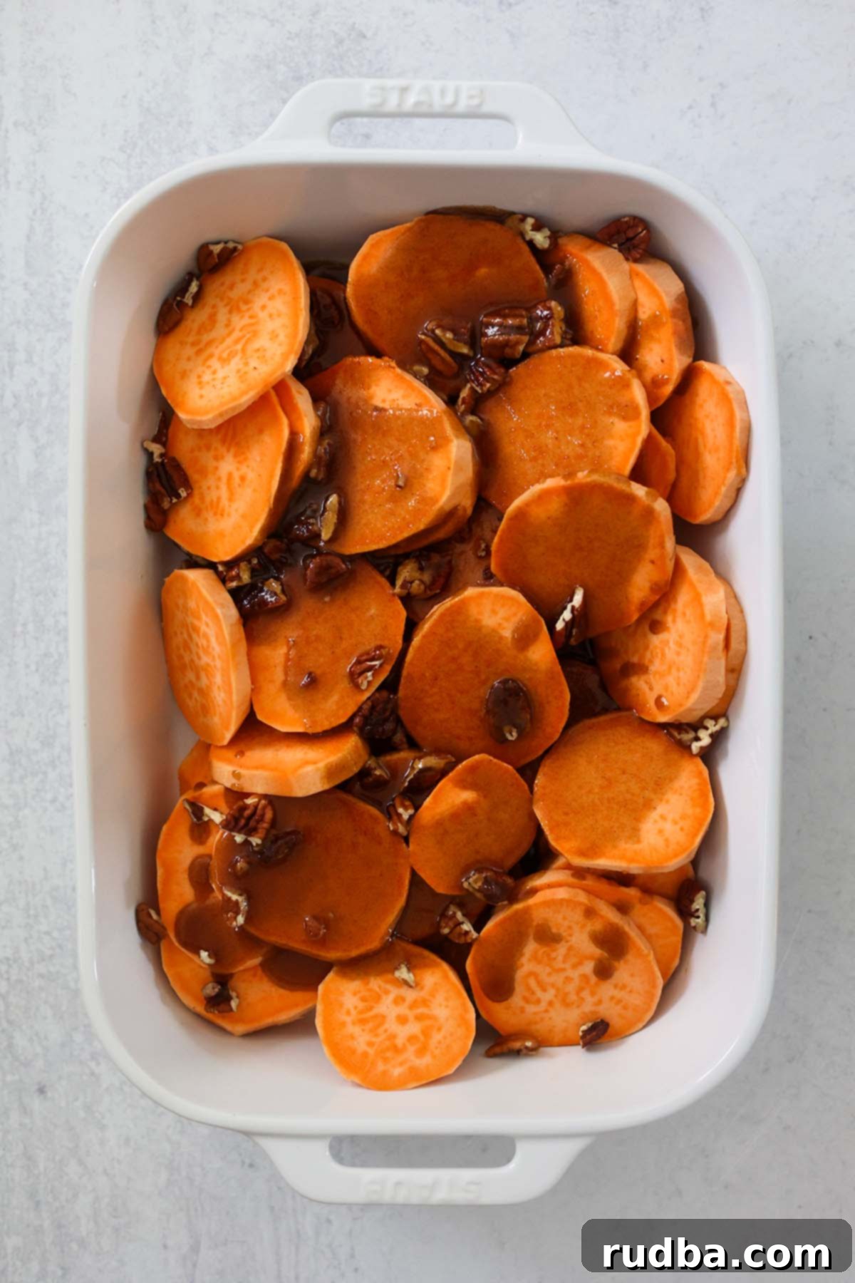 Bourbon-Kissed Sweet Potatoes 4 Sliced bourbon candied yams with a rich glaze and pecans, ready to be served from the dish.