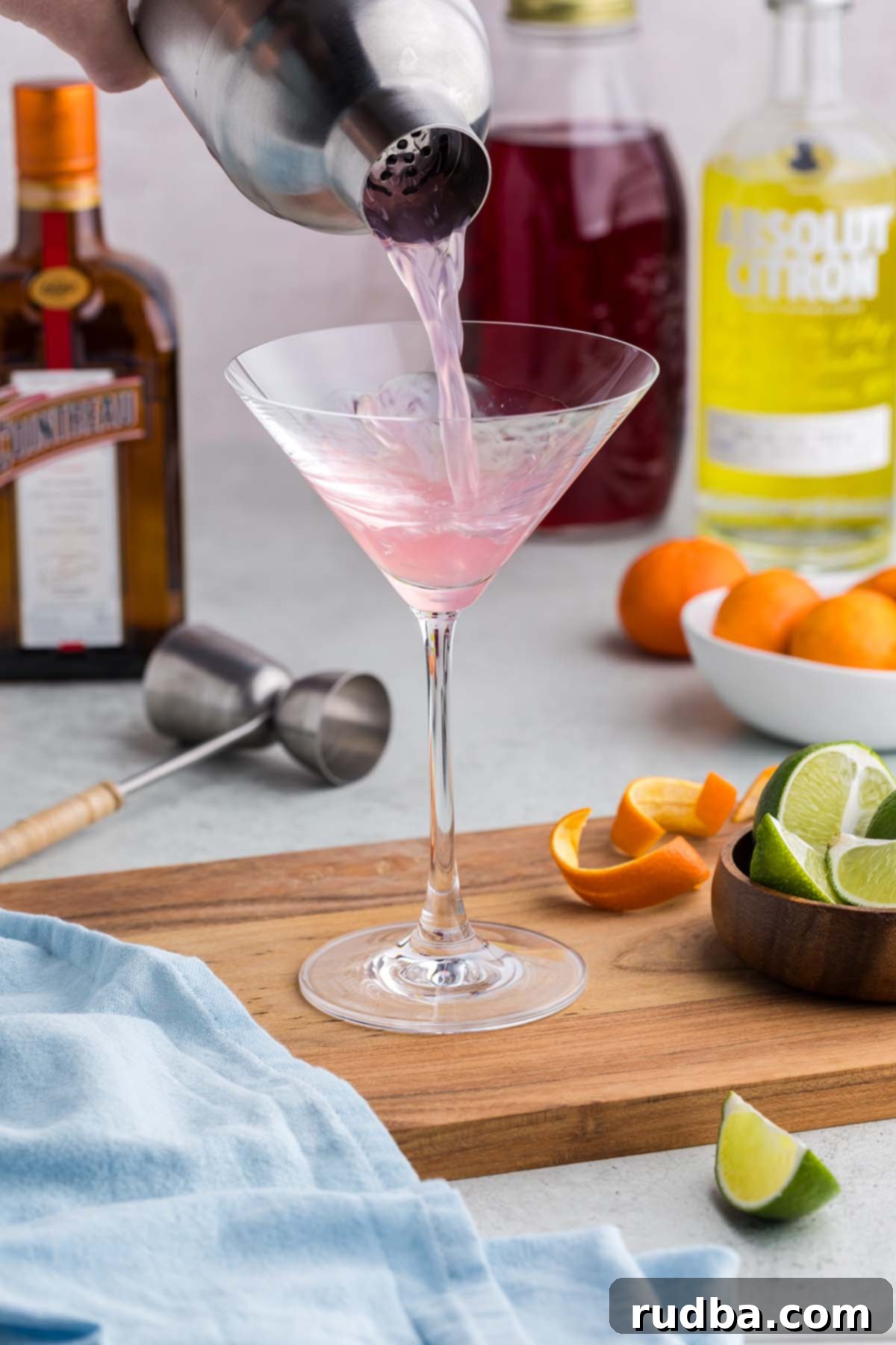 Classic Cosmopolitan Cocktail Recipe 4 A shaker pouring a drink into a martini glass