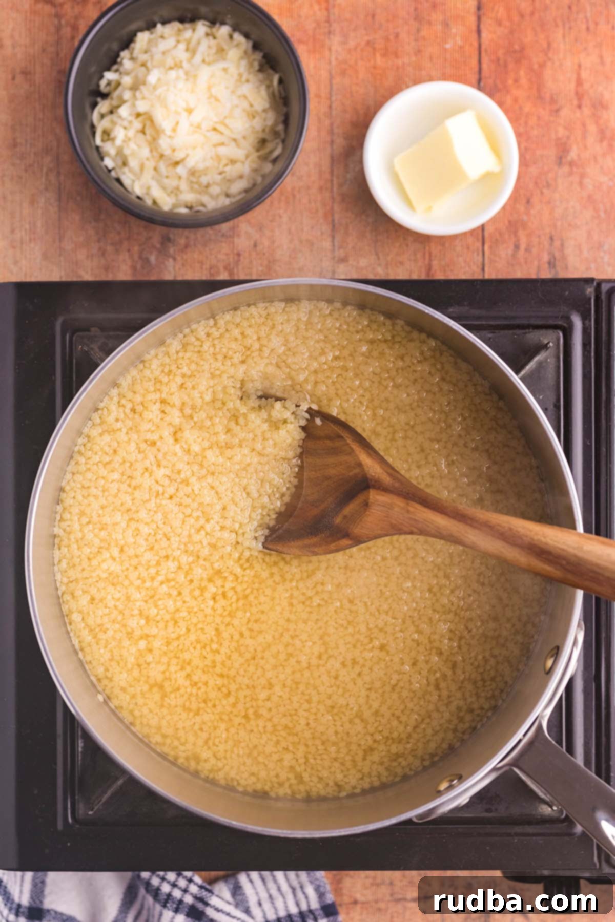 Pastina simmering gently in chicken stock on a stovetop, absorbing the liquid to create a creamy texture.