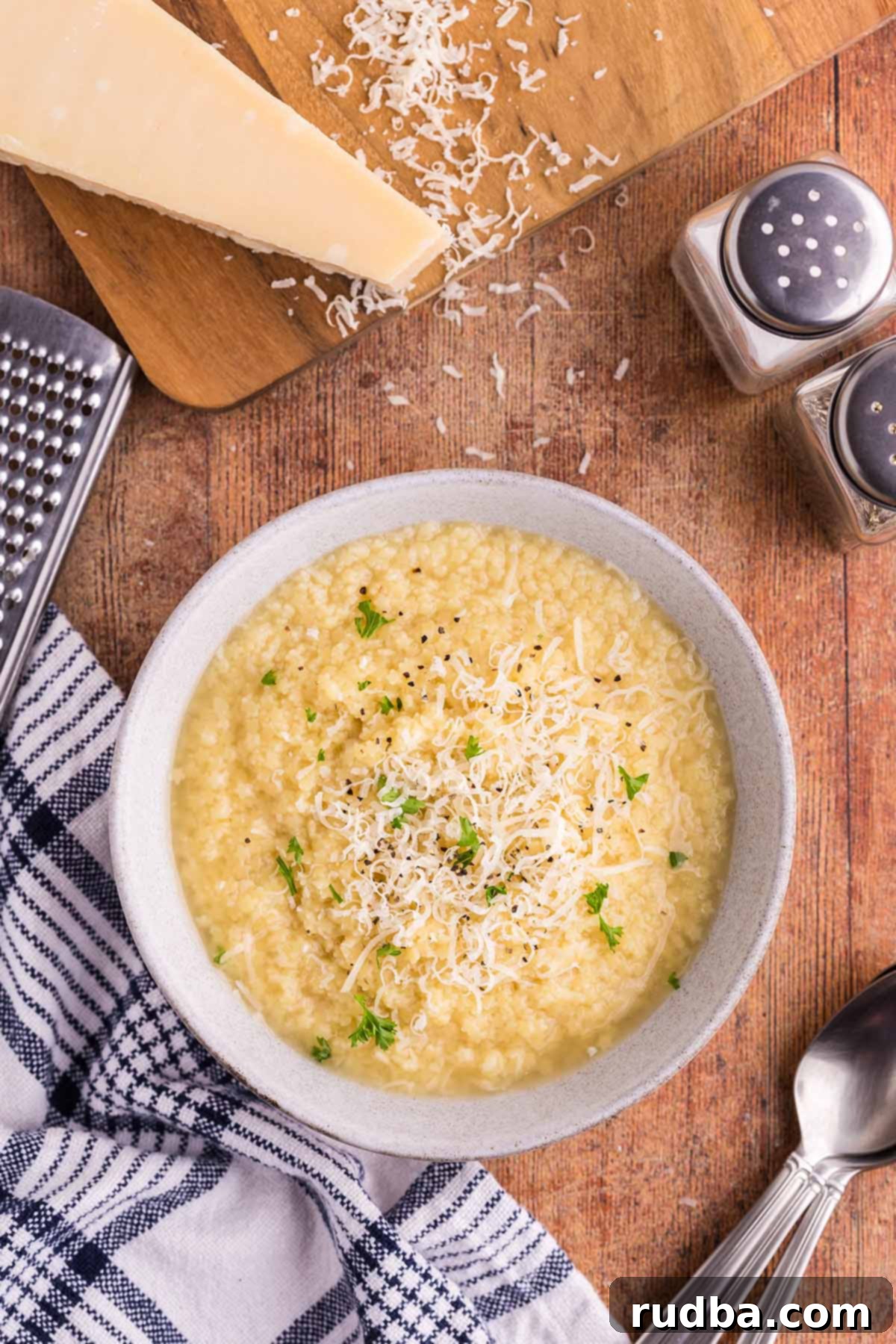 A close-up shot of a bowl of creamy pastina, garnished with fresh parsley, highlighting its comforting texture.