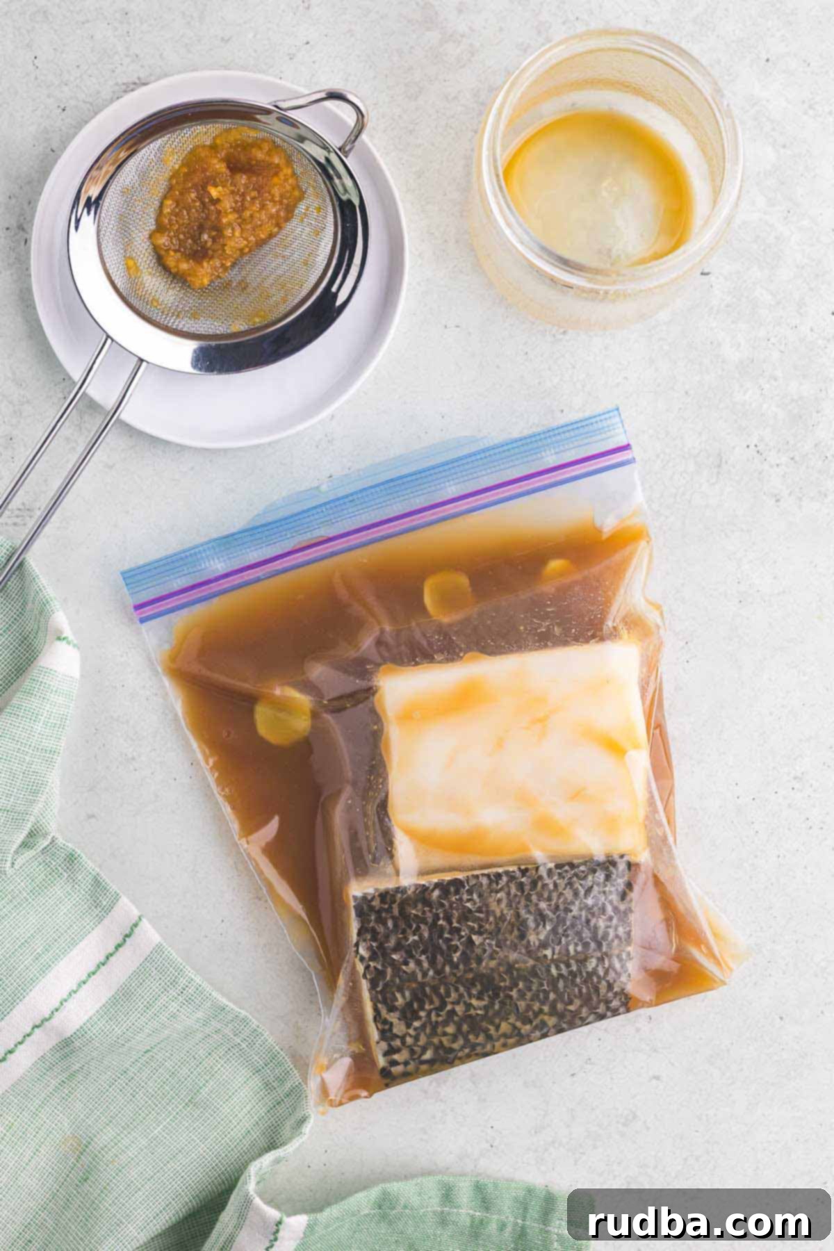 Savory Miso Glazed Chilean Sea Bass 4 Chilean sea bass in a plastic bag with a marinade.