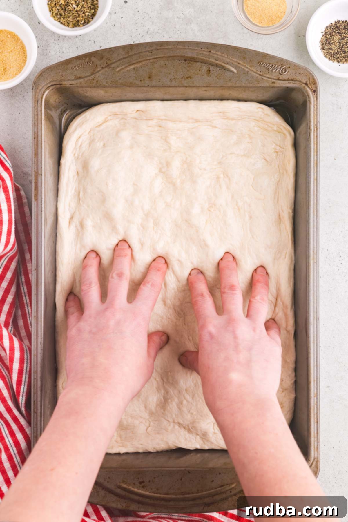 Classic Detroit Style Pan Pizza 4 Soft and airy pizza dough gently pressed into a 9x13 inch metal baking pan, generously coated with olive oil, ready for its final proofing before toppings are added.