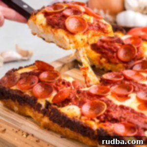 Classic Detroit Style Pan Pizza 7 Delicious Detroit style pan pizza on a cutting board, showcasing its unique square shape and caramelized edges.