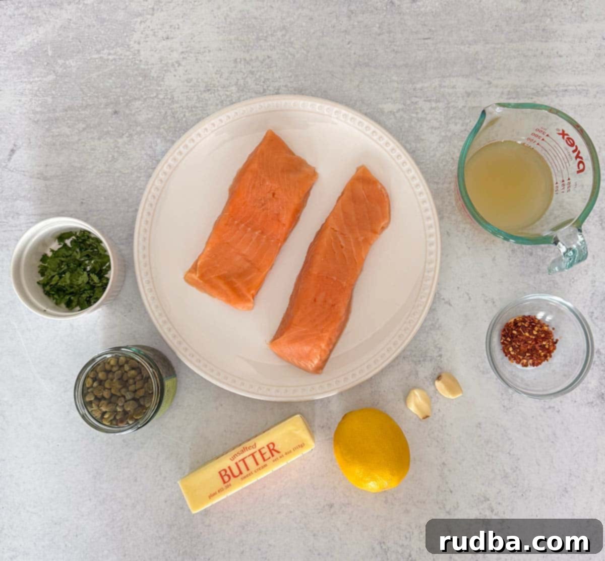 Two salmon fillets, chicken stock, garlic, parsley, capers, lemon, butter, and red pepper flakes. 