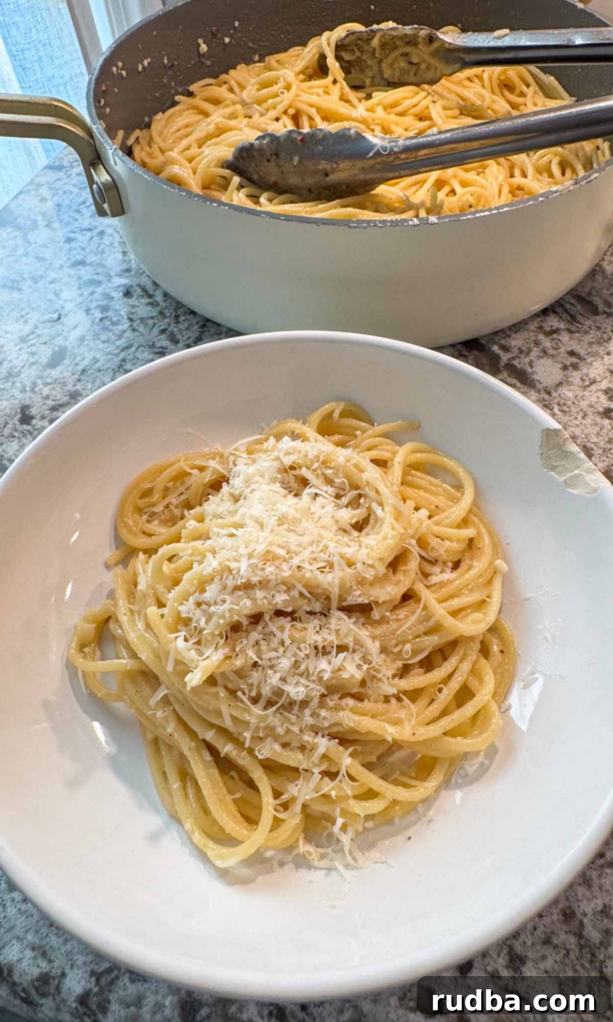 Golden Buttered Noodles 2 Buttered noodles in a bowl and a skillet in the background.