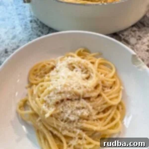 Golden Buttered Noodles 5 Buttered noodles in a bowl and a skillet in the background.
