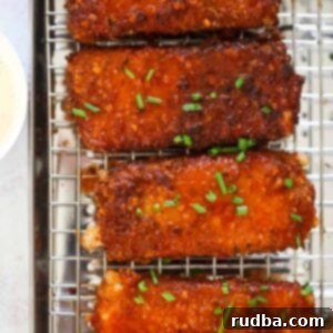 Honey Chipotle Mozzarella Poppers 5 Four honey chipotle fried mozzarella sticks on a rack.
