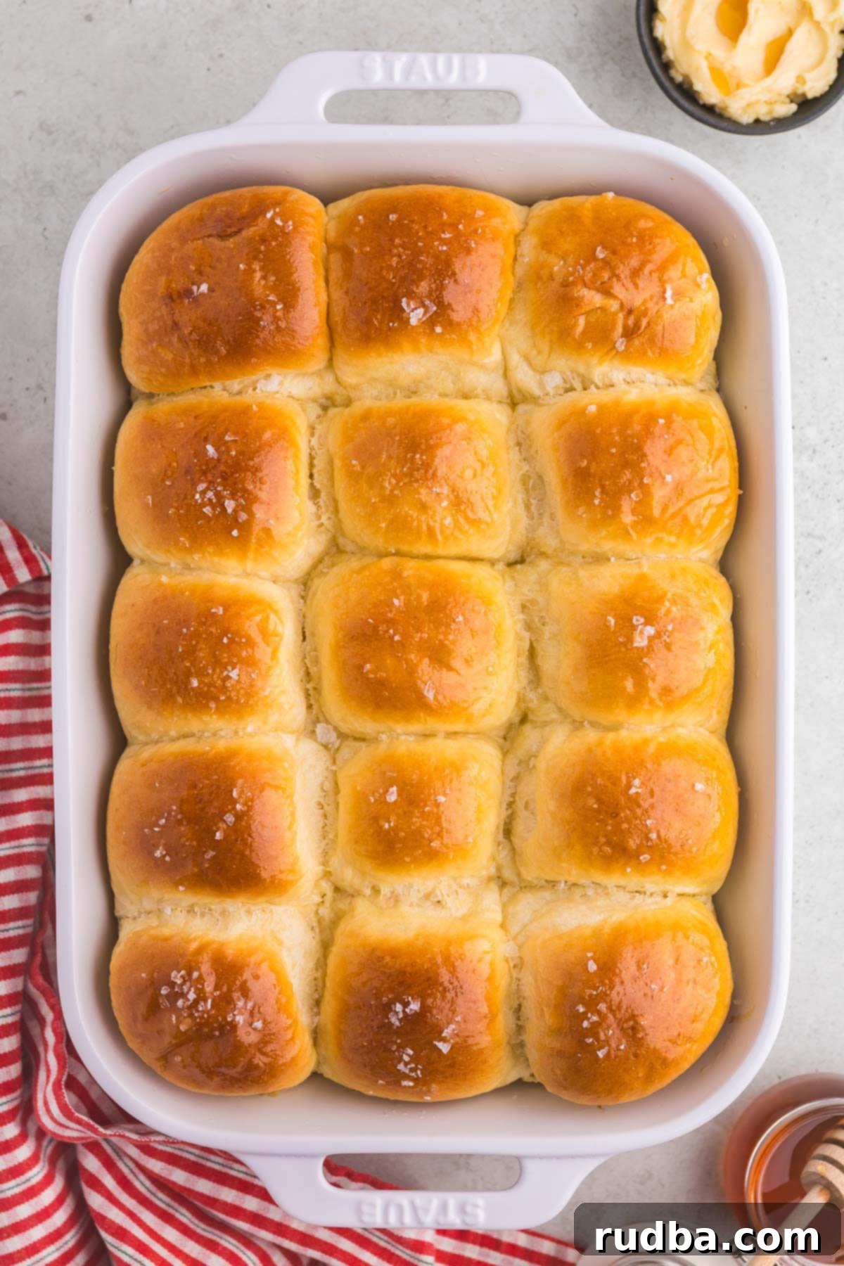 15 baked parker house rolls in a 9x13 white baking dish.