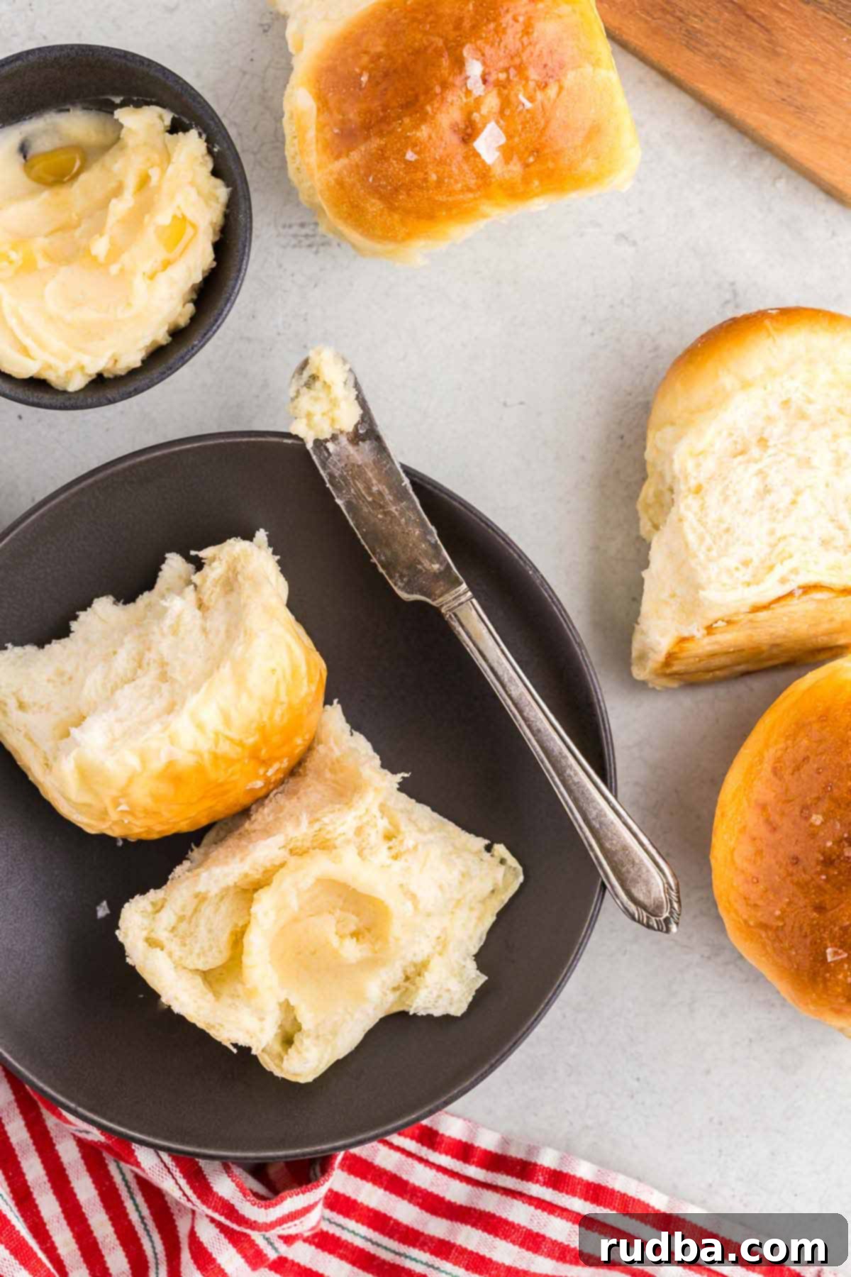 A roll with honey butter and a knife on the side.