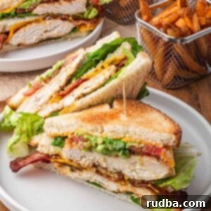 Ultimate Chicken Club 5 A chicken club sandwich with French fries on the side.