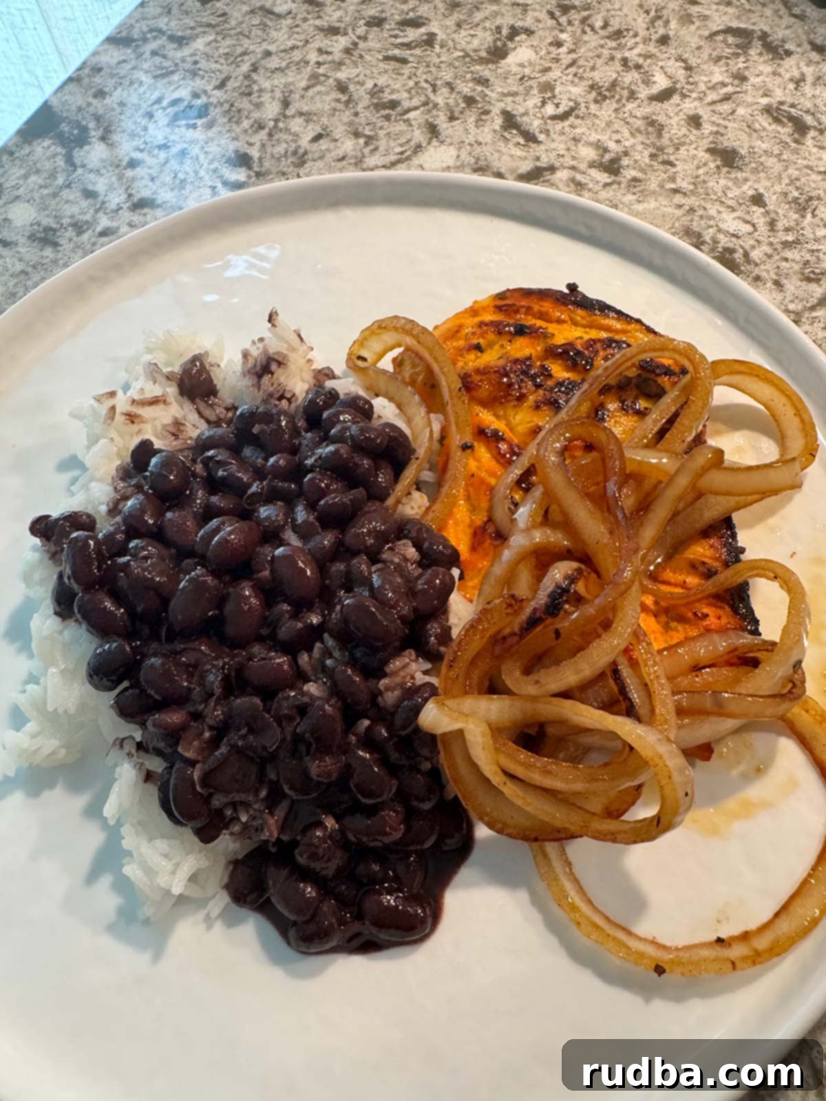 Zesty Cuban Pan-Seared Chicken 2 Grilled chicken with caramelized onions on top, served with a side of white rice and Cuban black beans.