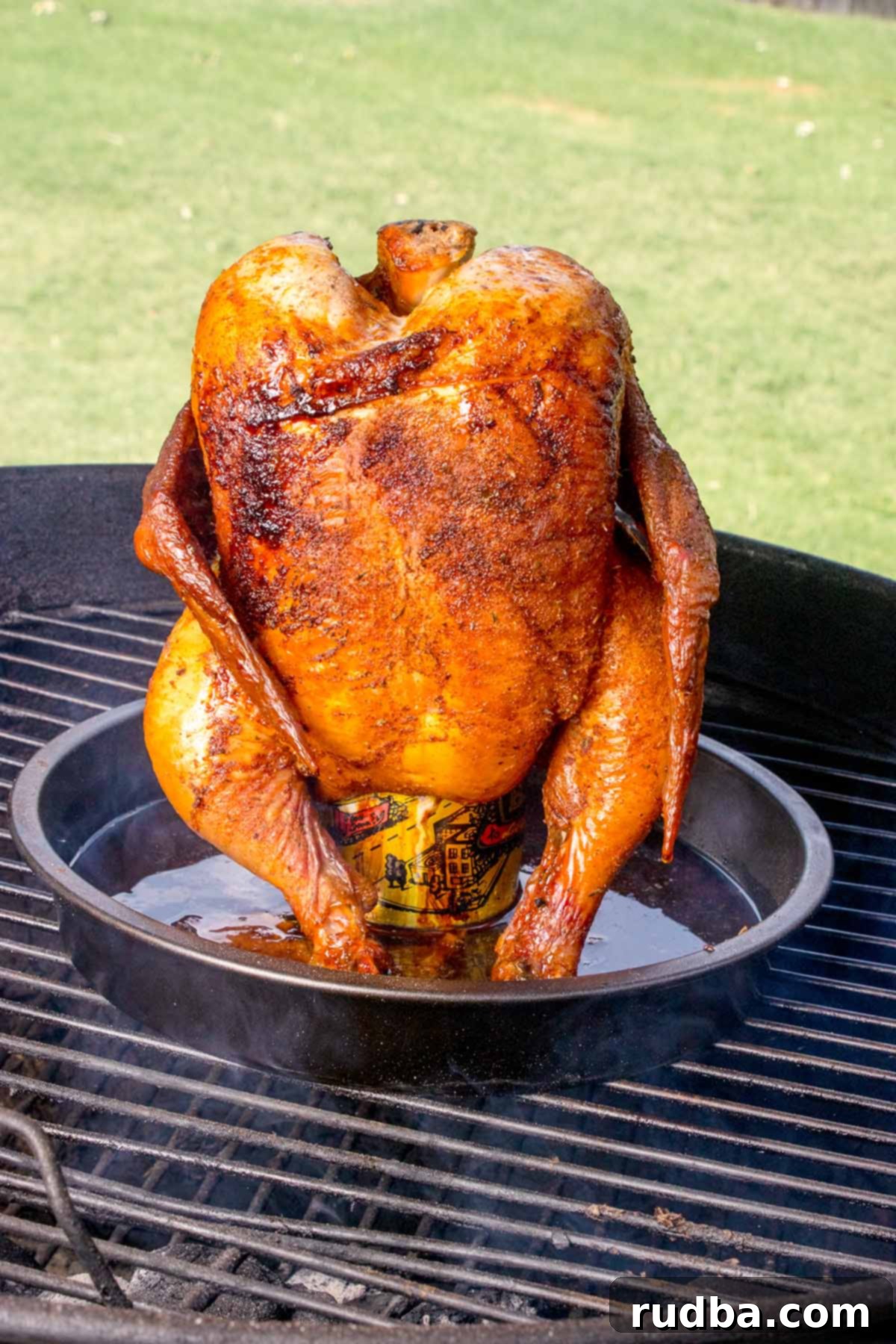 Smoky Beer-Kissed Chicken 2 A whole chicken cooked upright on a beer can on the grill.