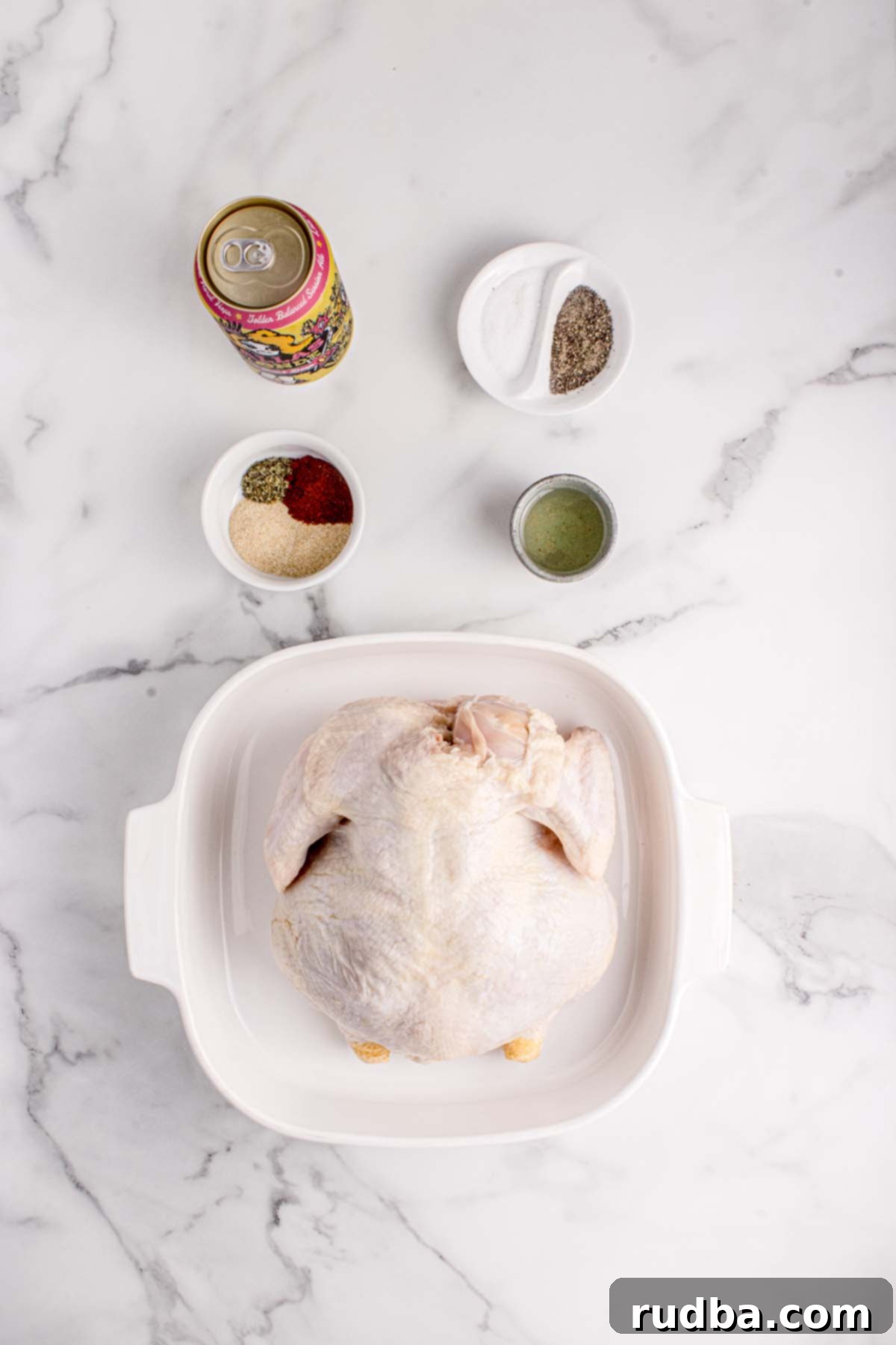 Smoky Beer-Kissed Chicken 3 A raw chicken, spices, a beer can, and olive oil.