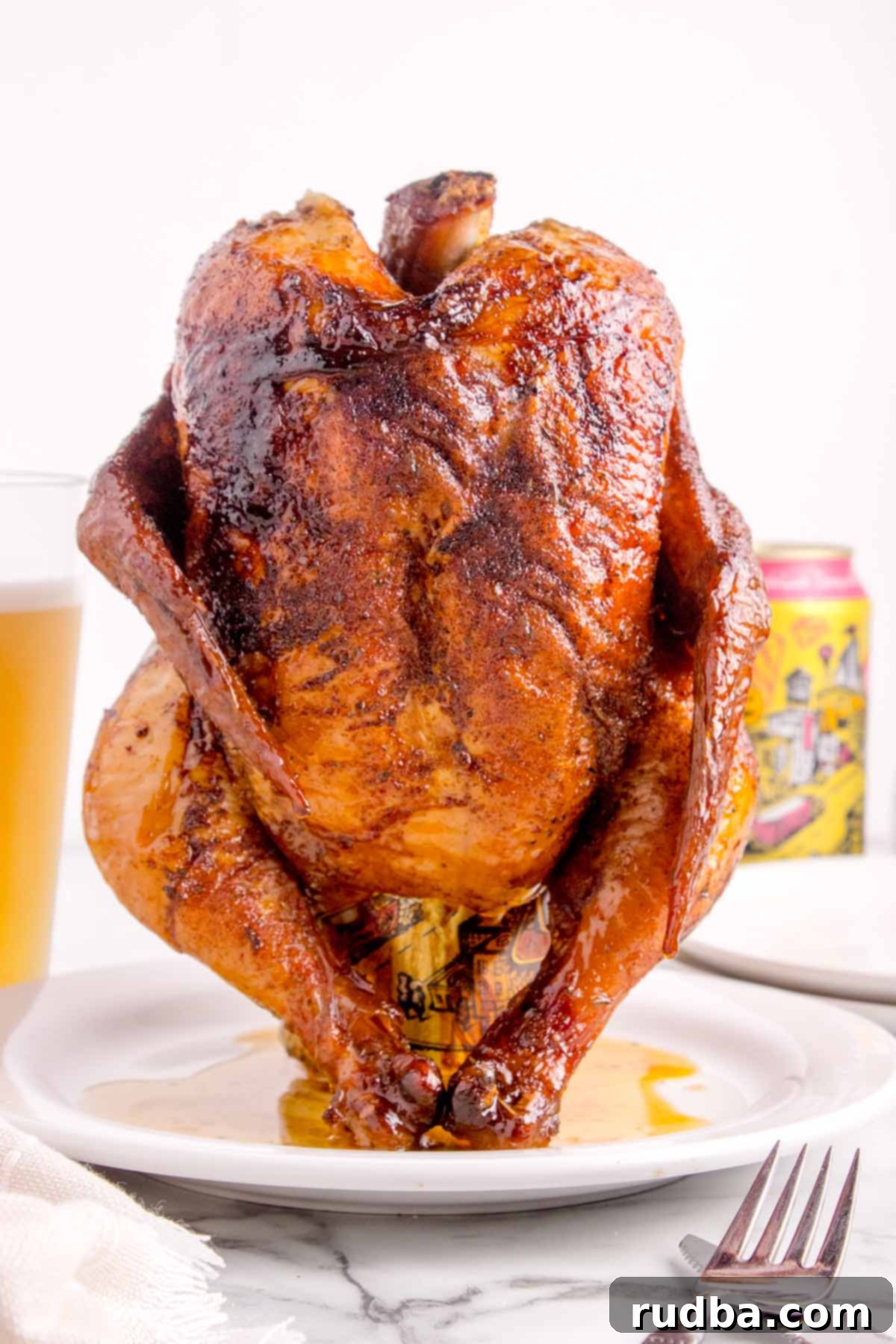 Smoky Beer-Kissed Chicken 5 A fully cooked whole chicken on a white plate.