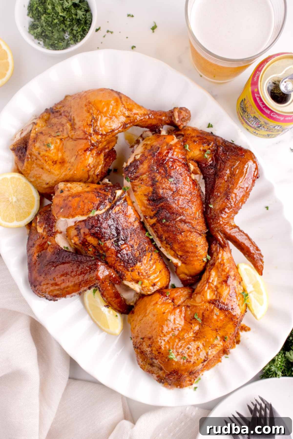 Smoky Beer-Kissed Chicken 6 Cooked chicken pieces on a white plate.