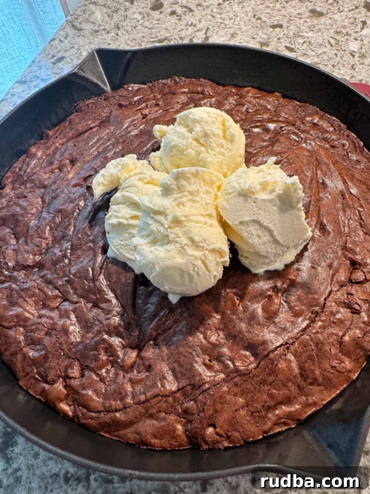 Warm Skillet Chocolate Brownie Bliss 2 Fudgy Chocolate Brownie Skillet topped with three scoops of creamy vanilla ice cream, served warm.