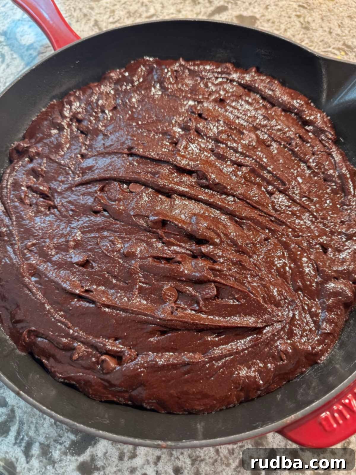 Warm Skillet Chocolate Brownie Bliss 4 Smooth, rich brownie batter spread evenly in a 10-inch cast iron skillet, prepared for baking to create a perfect fudgy dessert.