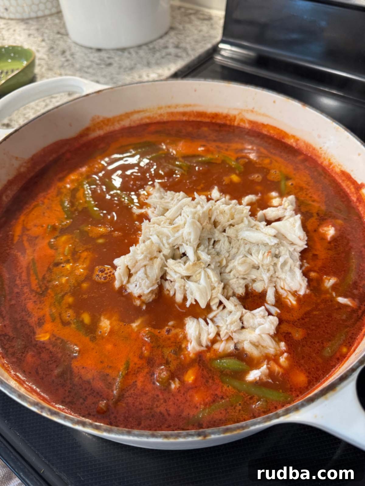 Maryland's Iconic Crab Soup 4 A large pot of Maryland crab soup simmering on the stovetop, releasing a delicious aroma.