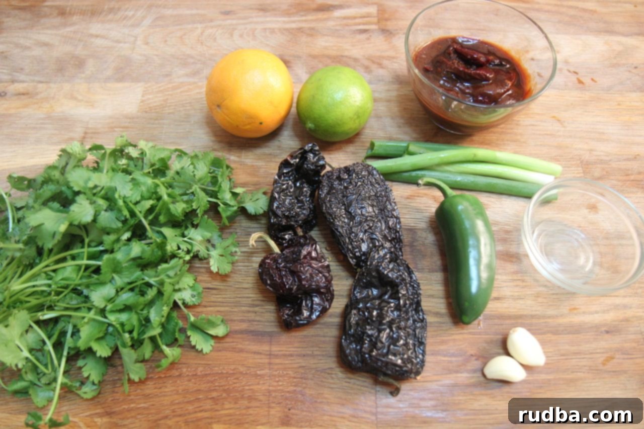Essential ingredients for homemade carne asada tacos, including roasted chilis, fresh cilantro, lemon and lime juice, garlic cloves, and a perfectly marinated flank steak, ready for grilling.