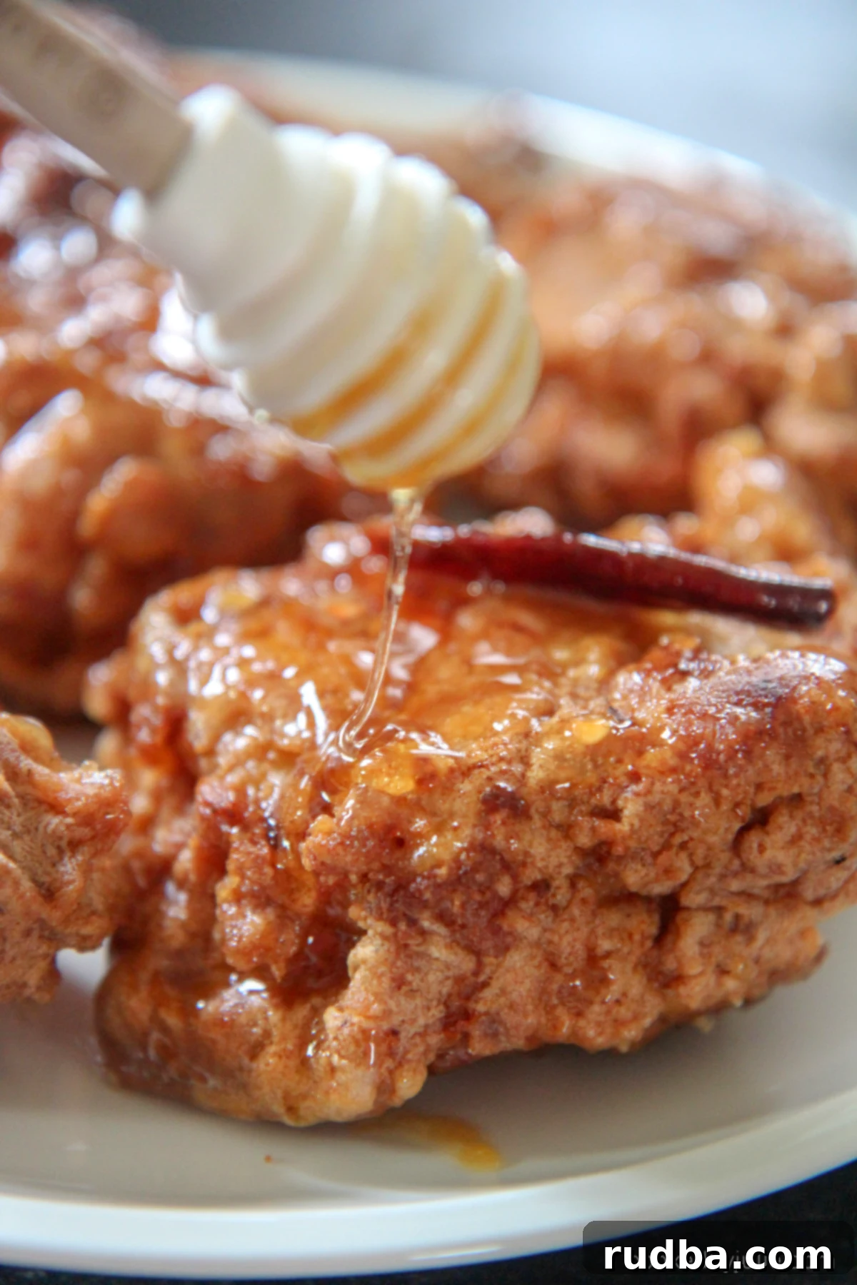 Close-up of golden brown honey fried chicken, glistening with sweet and savory sauce.