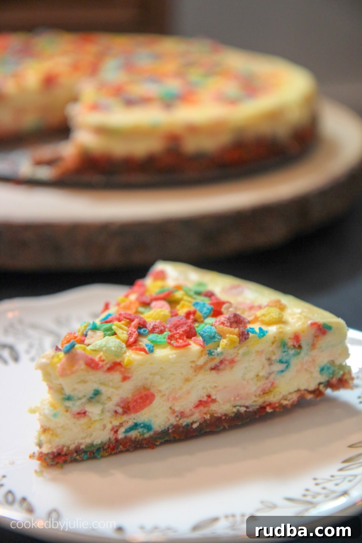 Close-up of a Fruity Pebble Cheesecake, showcasing the distinct and colorful cereal crust layer