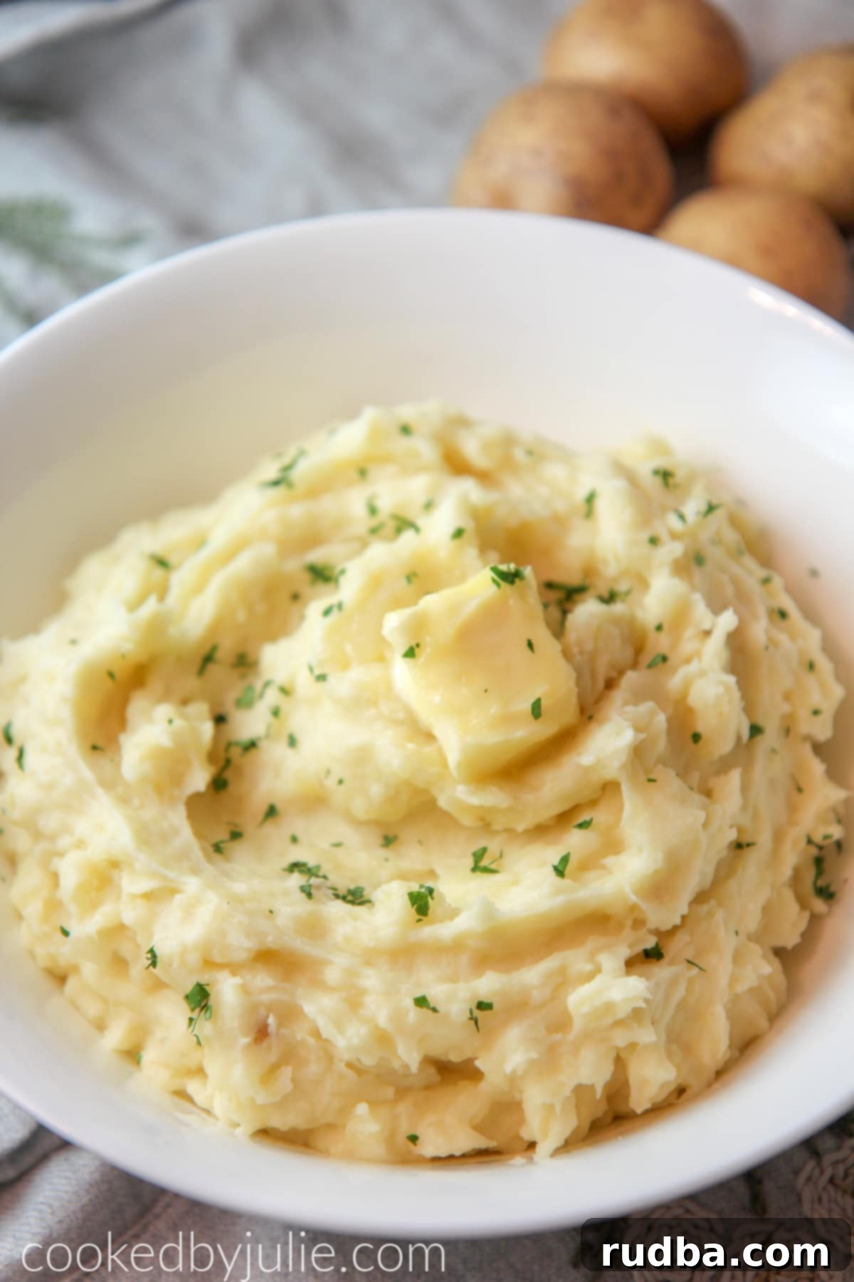 mashed potatoes in a bowl with butter and fresh parsley 