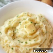 Velvety Potato Perfection 5 mashed potatoes in a bowl with butter and fresh parsley