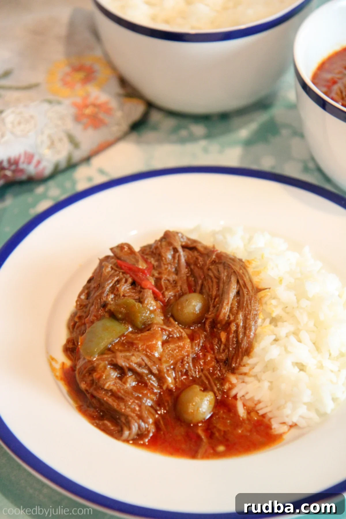 Plate of Ropa Vieja with white rice, garnished with fresh cilantro