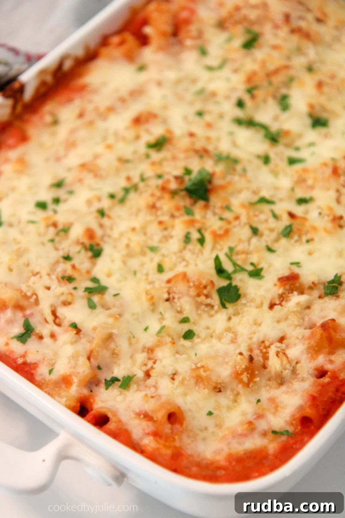 Olive Garden Baked Ziti in a white casserole dish with fresh parsley on top, ready to be served.