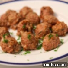 Savory Baked Turkey Meatballs 6 A white and blue plate of turkey meatballs with fresh parsley