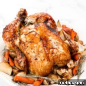 Golden Honey Glazed Chicken 5 a whole honey roasted chicken on a platter with herbs and carrots