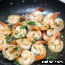 Close-up of cooked garlic butter shrimp in a skillet