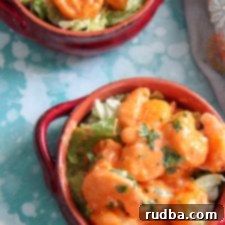 Close-up of fried shrimp coated in a luscious mayo-based dressing, garnished with fresh parsley