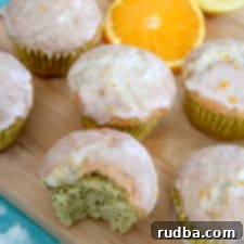 Zesty Orange Lemon Poppy Seed Muffins 4 orange lemon poppy seed muffins on a wooden board with orange slices
