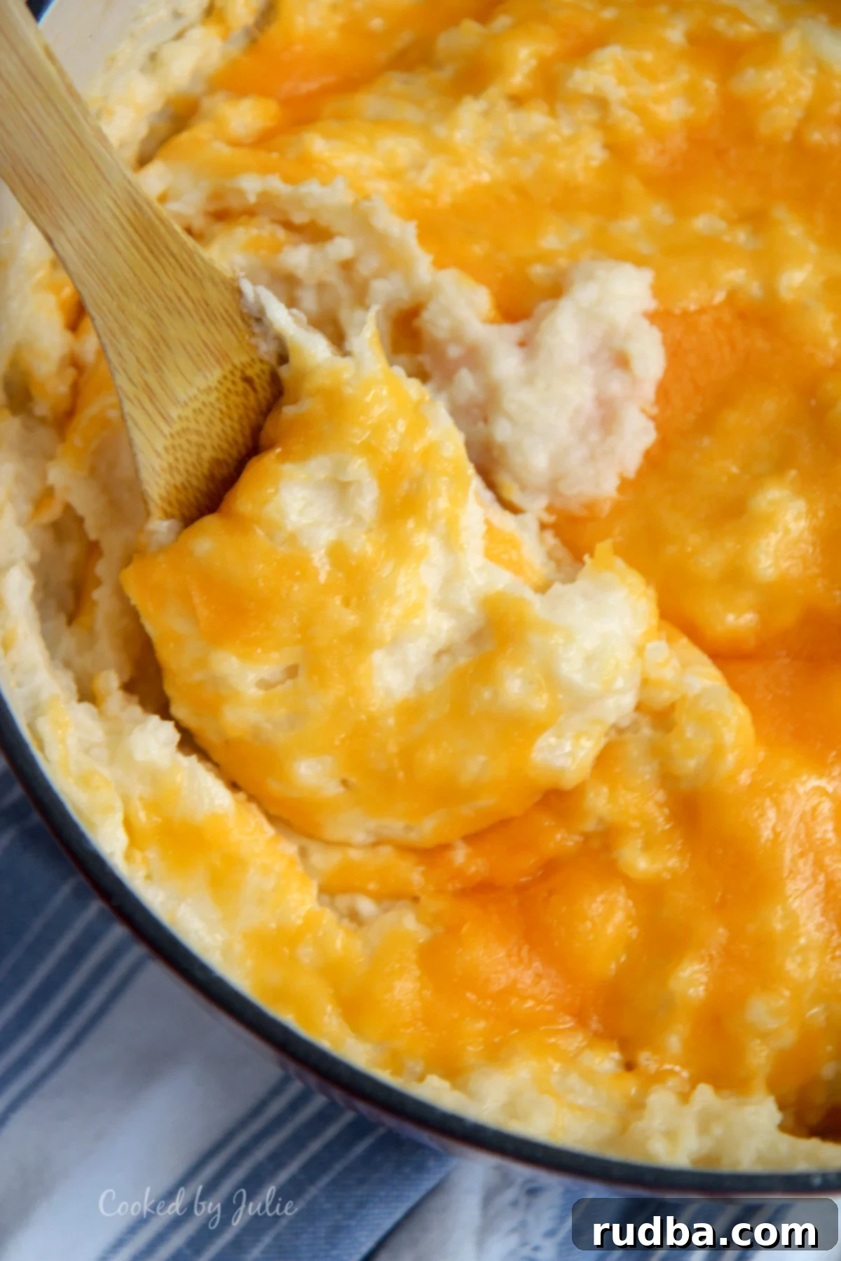 cheddar mashed with a wooden spoon and blue and white table cloth