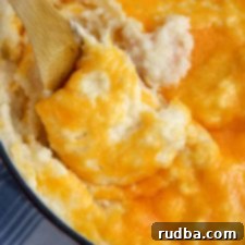 cheddar mashed with a wooden spoon and blue and white table cloth