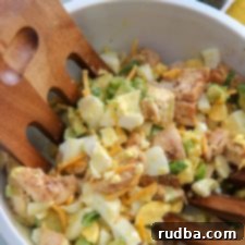 avocado chicken salad in a white bowl and wooden salad mixers