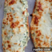 Cheesy Spinach Artichoke Bread 7 two loafs of cheesy spinach artichoke bread on a baking sheet
