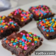 Galaxy Fudge Bites 5 brownies with rainbow chips on top of a white plate
