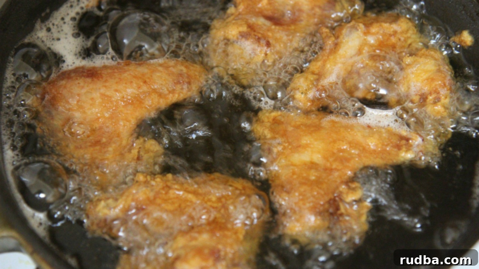 Raw brined chicken wings, meticulously patted dry on a paper towel, ready for coating and deep frying to ensure maximum crispiness and prevent oil splatter.