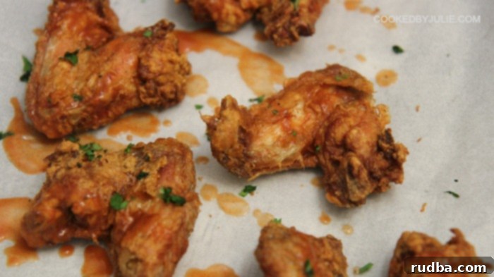 A selection of delicious crispy chicken wings, some plain and some tossed in a spicy hot sauce, presented with a side of creamy blue cheese dip.