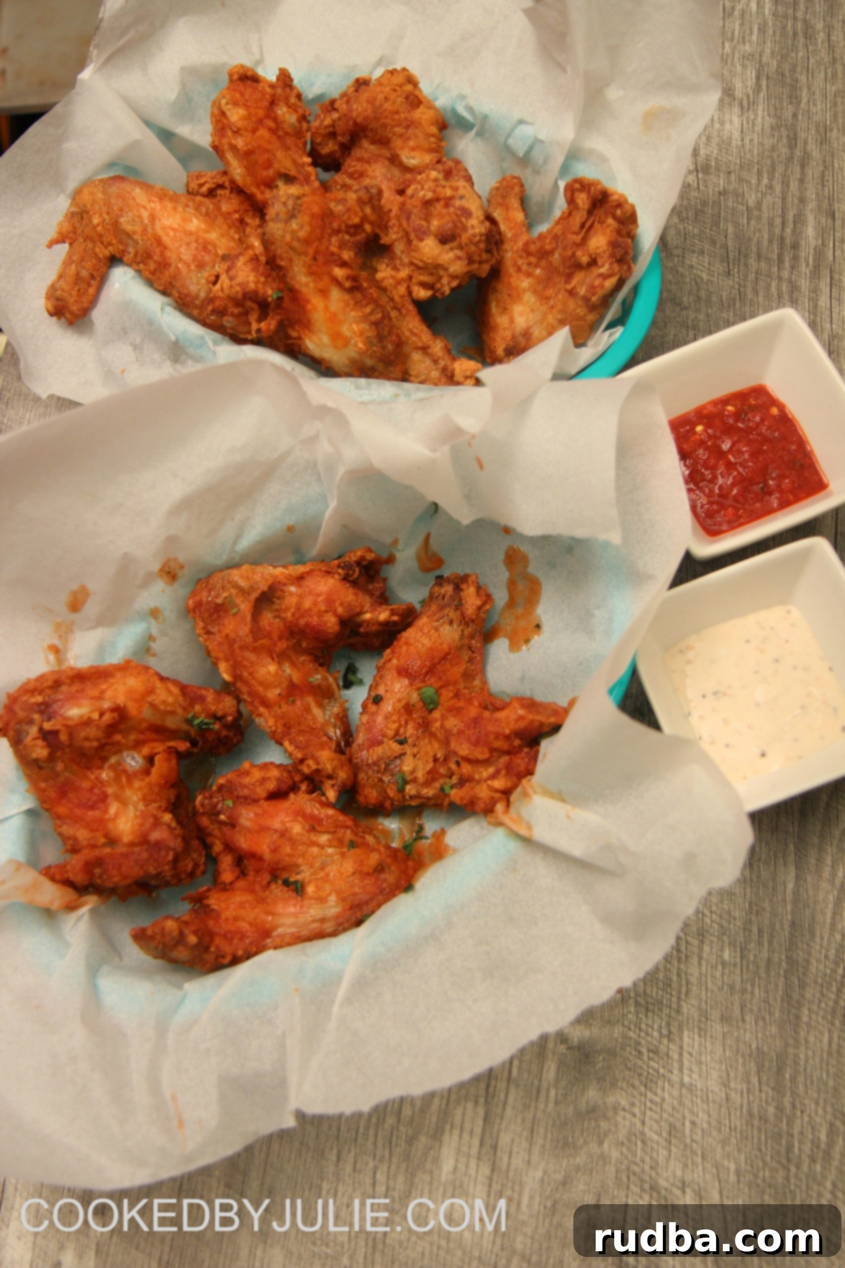 Delicious deep-fried crispy chicken wings served with creamy blue cheese dip and a side of fresh celery, inviting readers to try this ultimate homemade recipe from CookedByJulie.com.