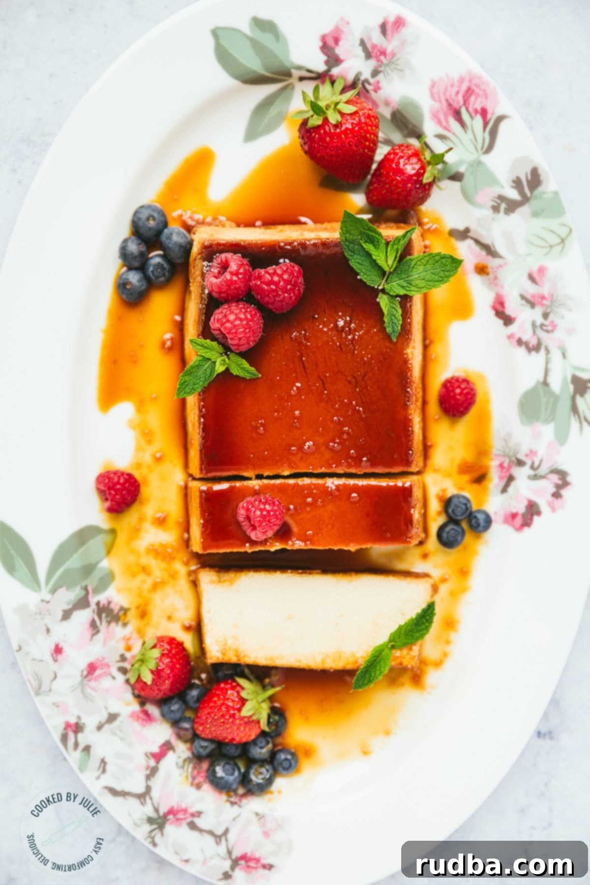 Crème Caramel 3 A perfectly sliced flan with a luscious caramel sauce, garnished with fresh berries and a sprig of mint, showcasing its smooth, creamy texture.