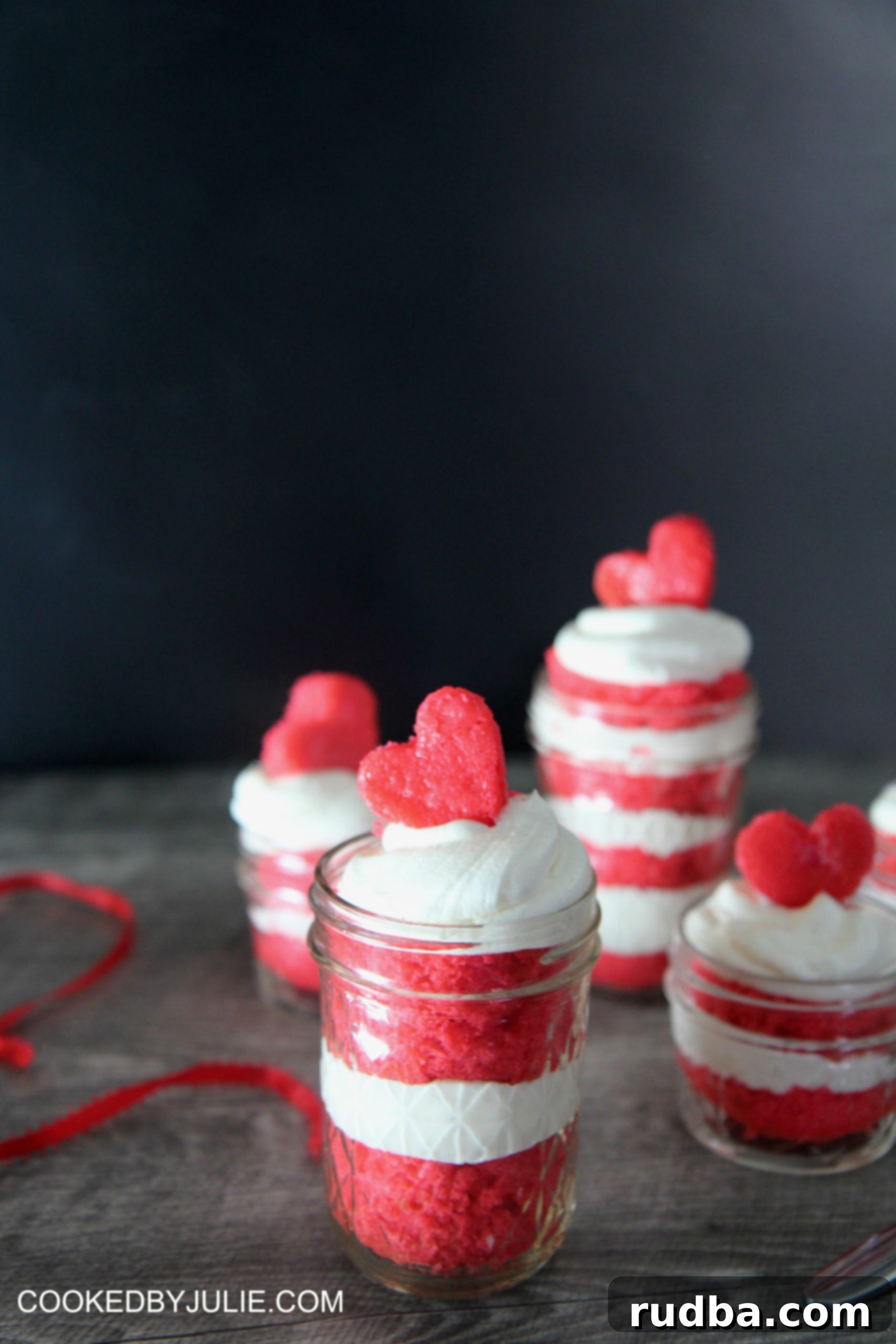 These cute desserts can be given away as gifts. Red Velvet Cake Jars are stacked with cake and frosting, ready for gifting.