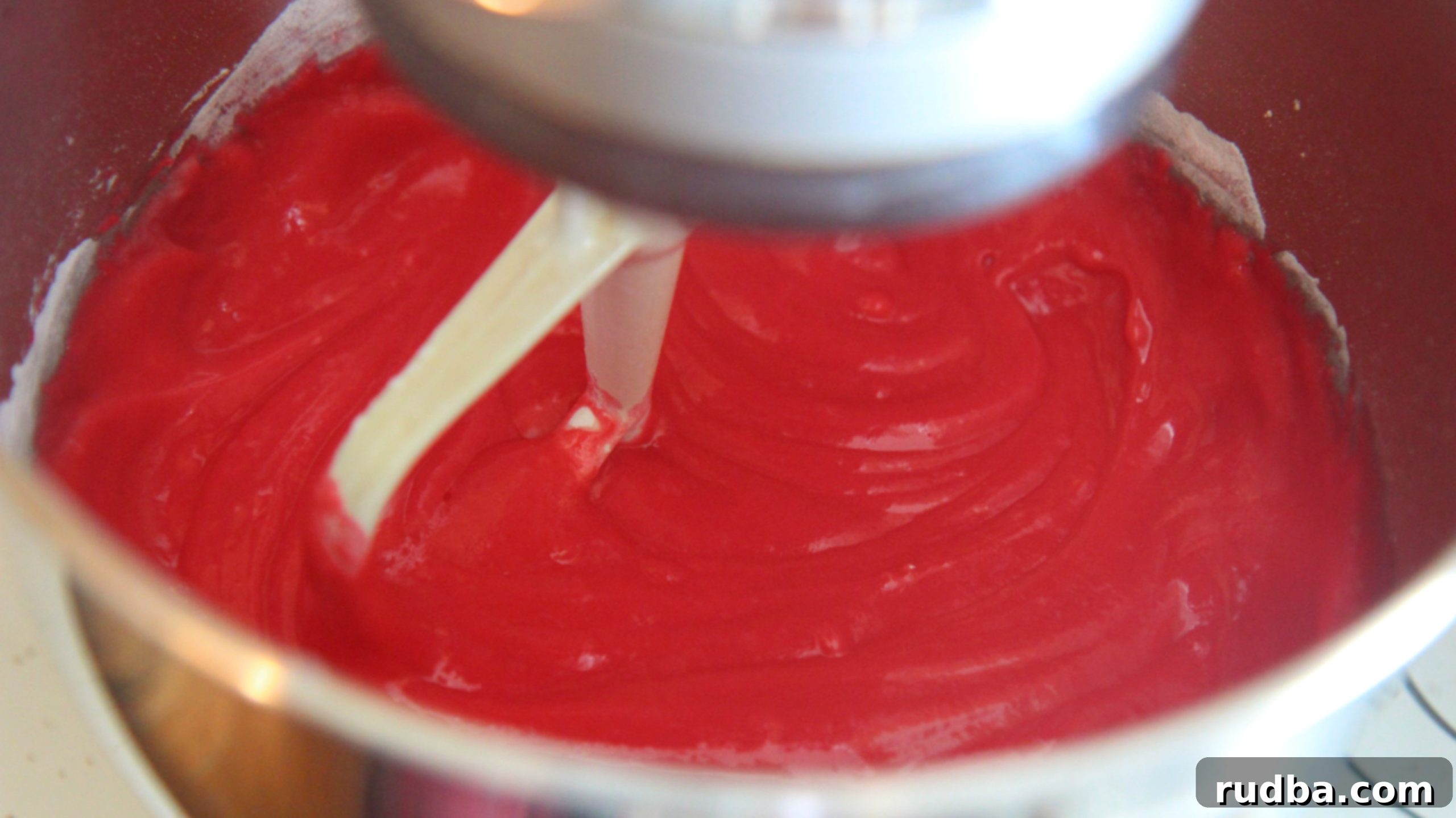 Mix and blend up the cake batter so it's bright and light, ensuring a vibrant red velvet color for the cake jars.