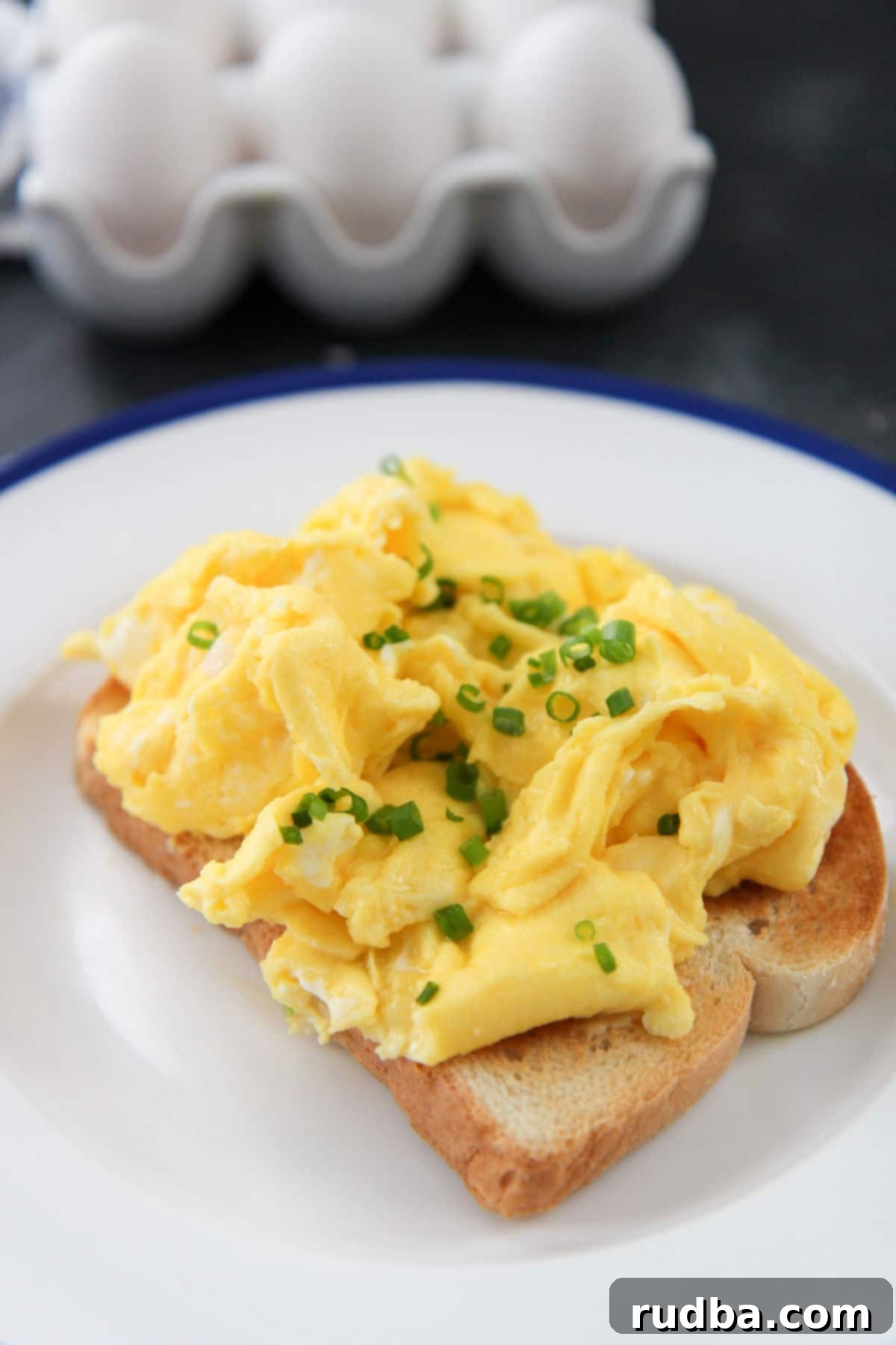  toast on a white and blue plate with eggs in the background 